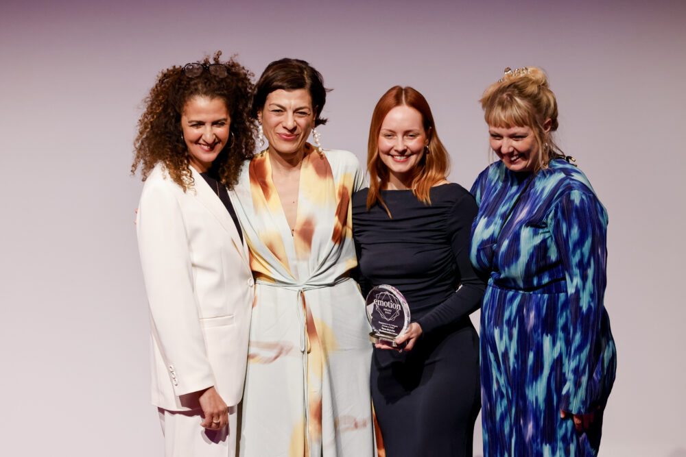 Das Foto zeigt eine feierliche Preisübergabe. Mitarbeiter*innen der Neuen deutschen Medienmacher*innen nehmen den Emotion Award 2024 entgegen.