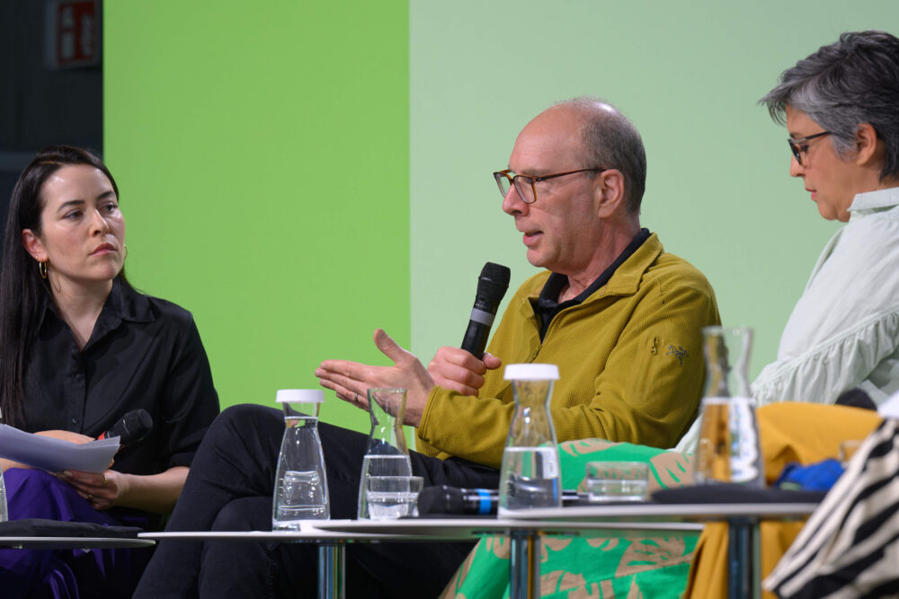 Das Bild zeigt drei Personen auf einem Panel.