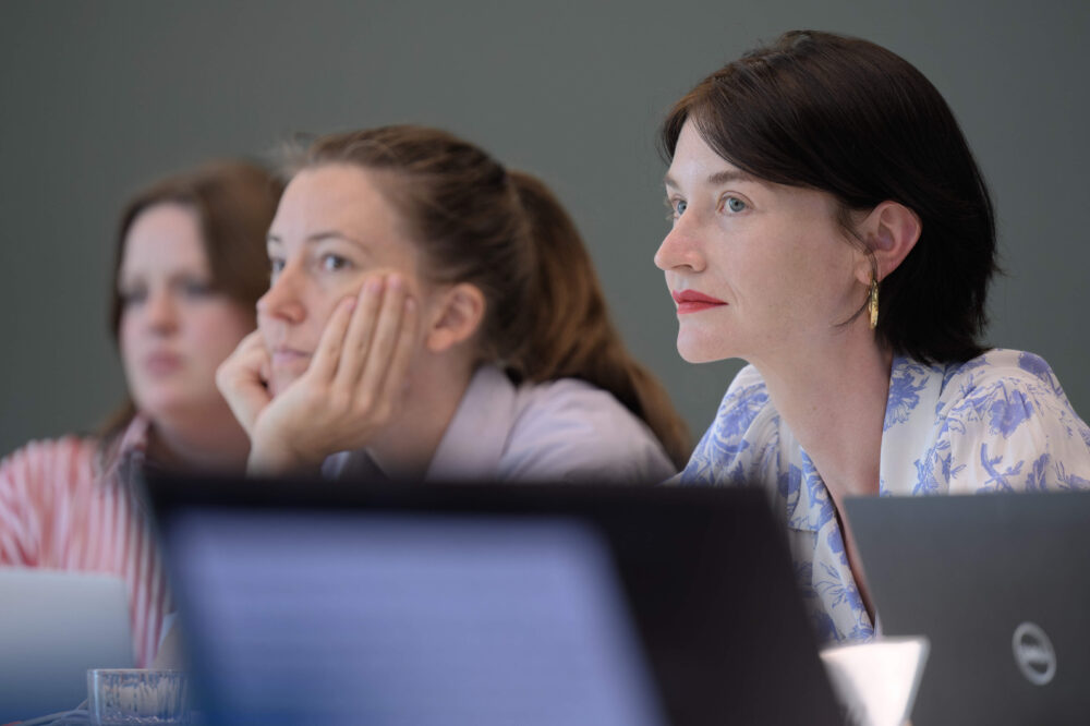 Das Bild zeigt zwei Frauen mit Laptops in einer Sitzung.