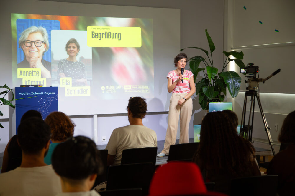 Ella Schindler, Co-Vorstandsvorsitzende der Neuen deutschen Medienmacher*innen begrüßt die Teilnehmenden von "Take Your Space"