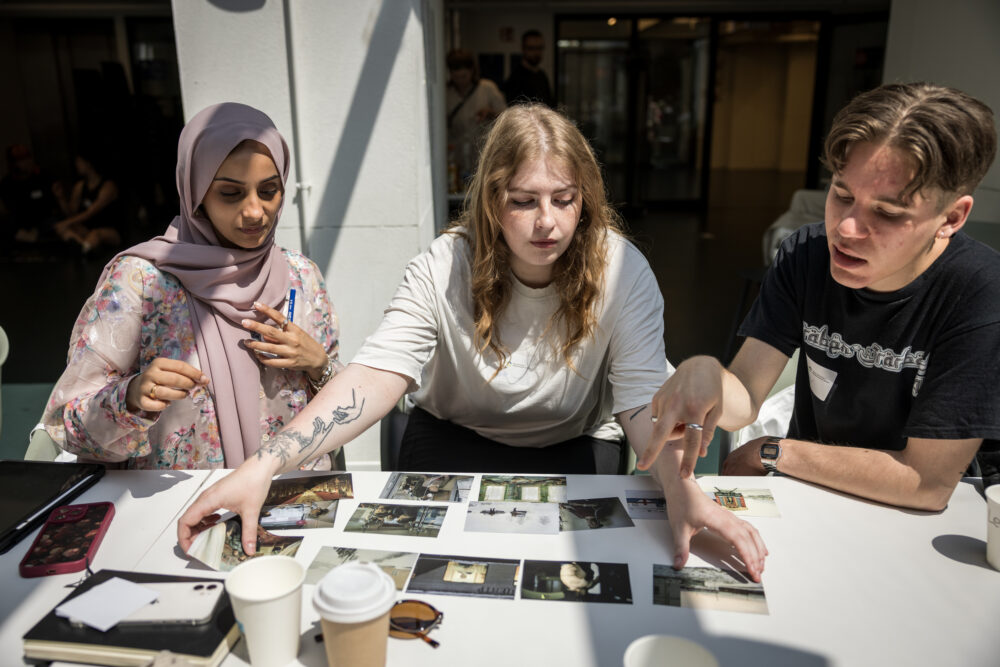 Das Bild zeigt drei Personen bei einem Workshop von Beyond the Frame