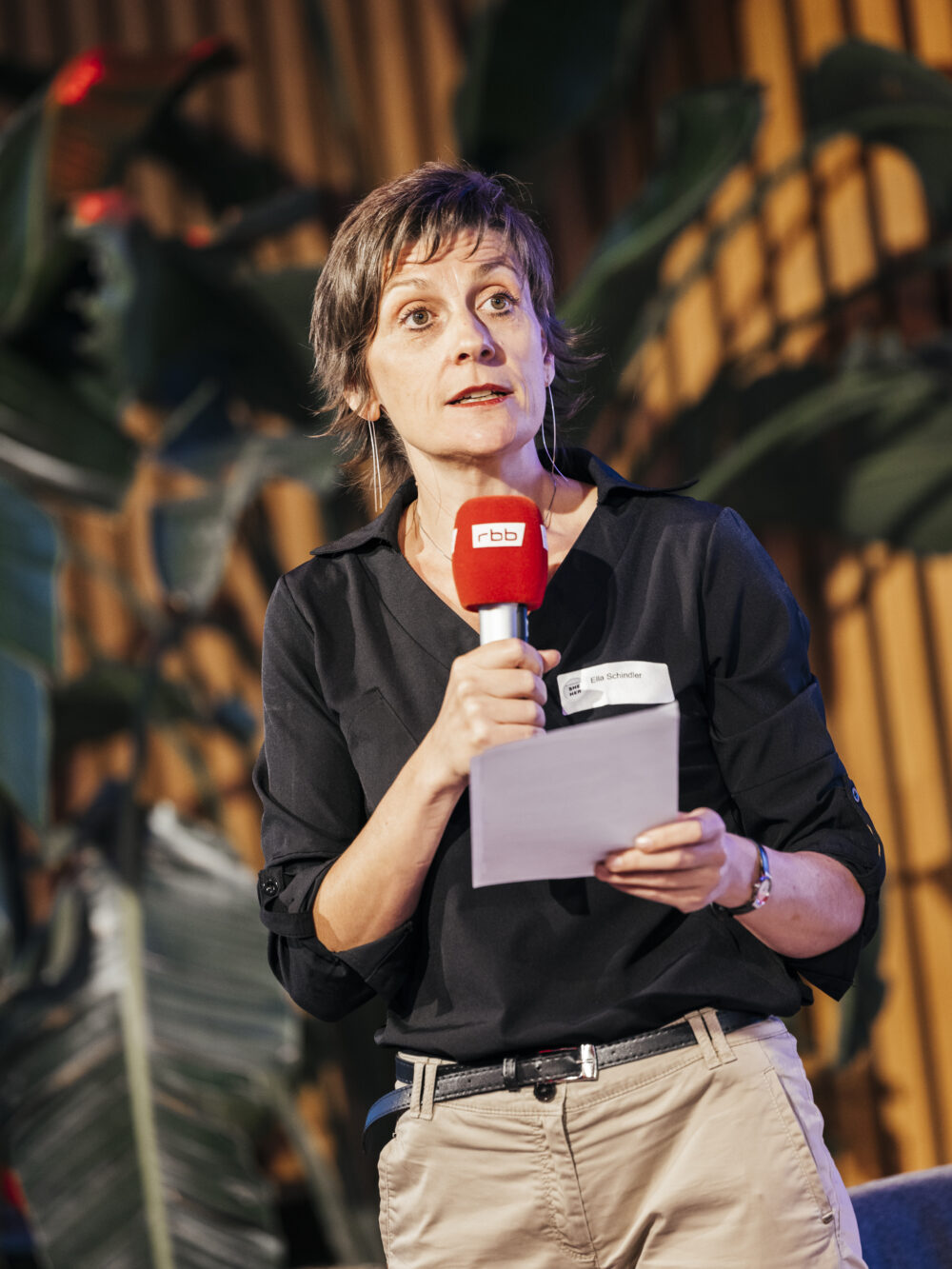 Das Bild zeigt ein NdM-Mitglied, das auf einer Veranstaltung in ein Mikrofon spricht.