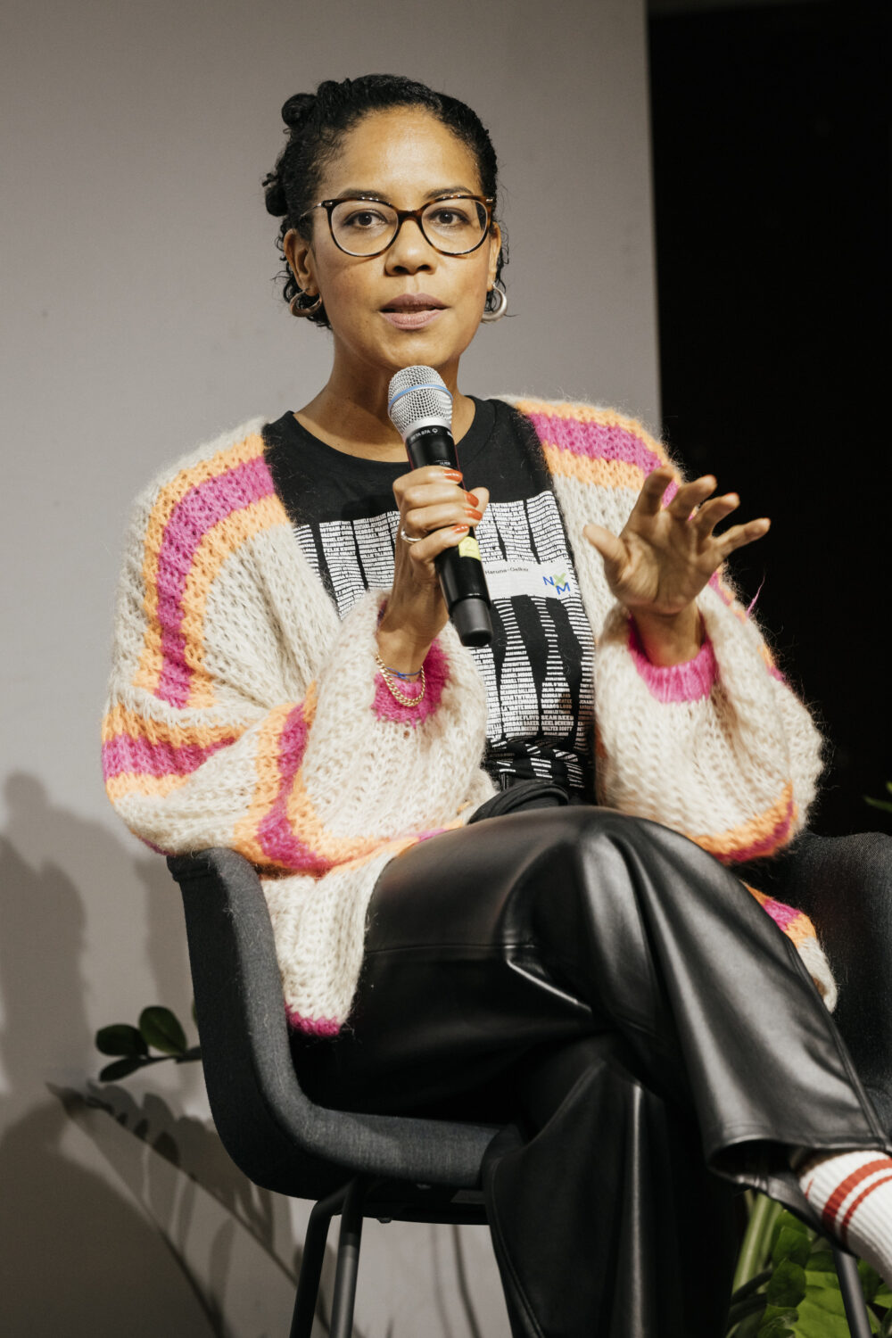 Eine Frau, die auf einem Veranstaltungspanel sitzt, spricht in ein Mikrofon