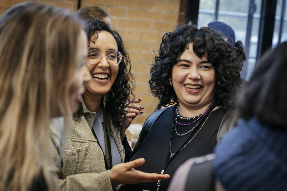 Teilnehmer*innen der NxM 2024 unterhalten sich lachend